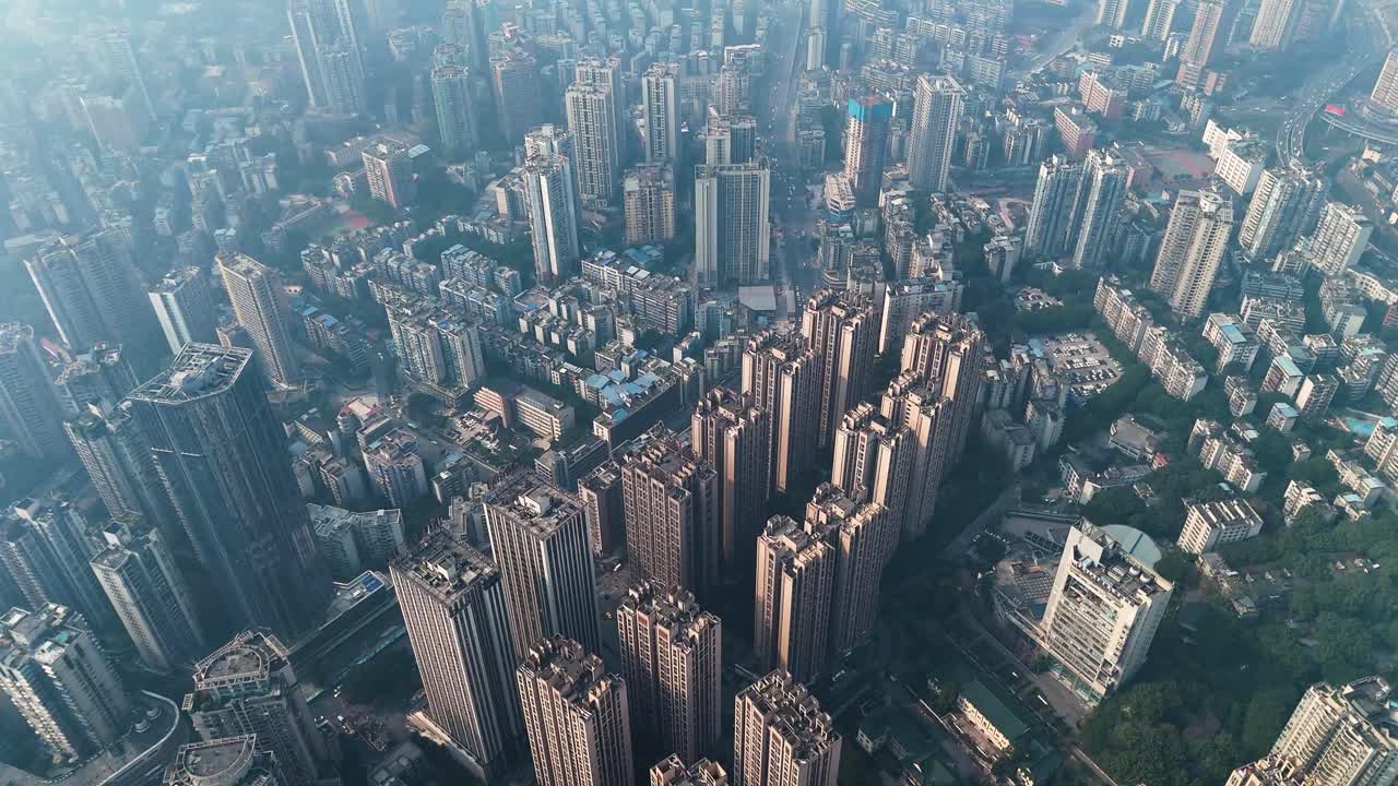 Aerial view of a densely packed residential area in Chongqing, China, showcasing high-rise apartment buildings. The city’s vast urban development and dense housing structures highlight rapid growth.