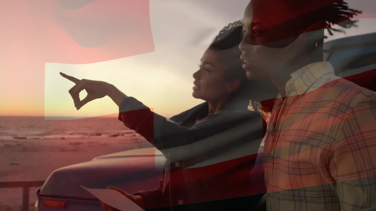 Pointing towards horizon, couple with Swiss flag overlay at beach sunset