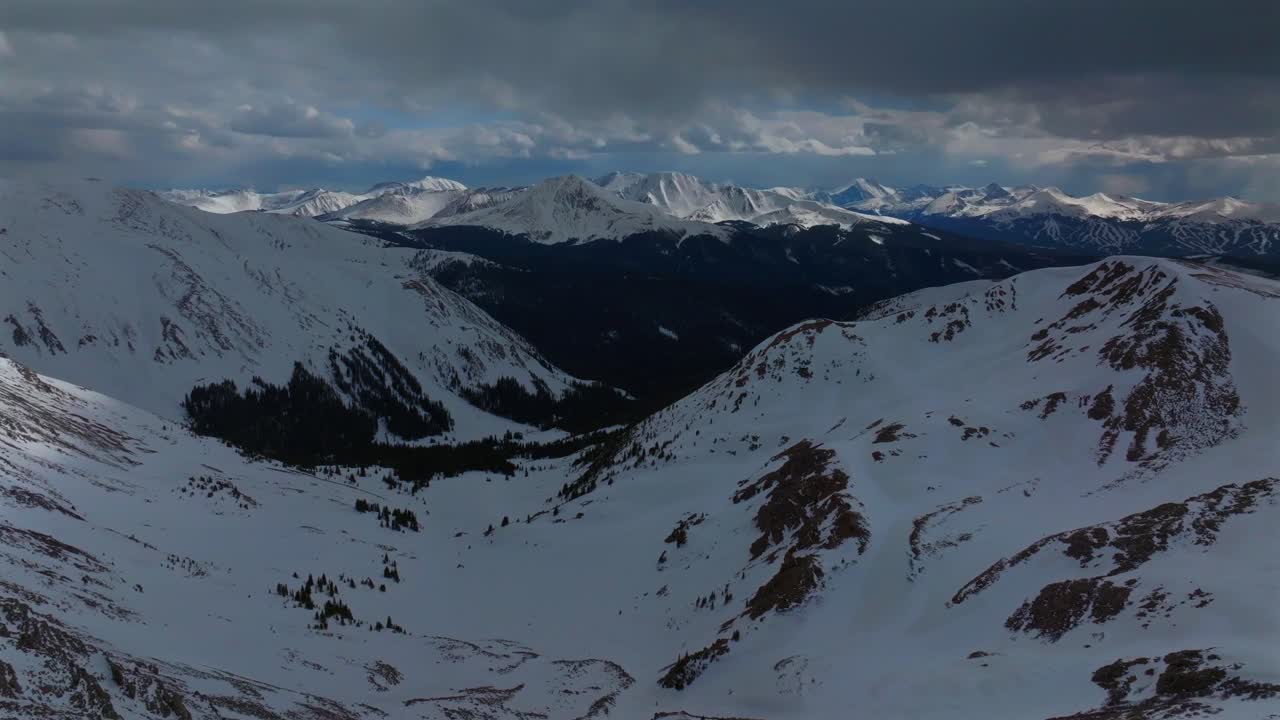 Breckenridge Bald Mountain Boreas Pass Quandary peak deep snow covered Rocky Mountain peaks winter spring afternoon Montezuma Deer Creek aerial drone Colorado backcountry dark storm clouds forward pan