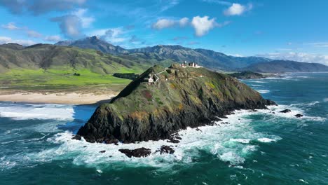 aerial shot of point sur lighthouse along big sur highway 1, waves crashing below ocean coastline, california