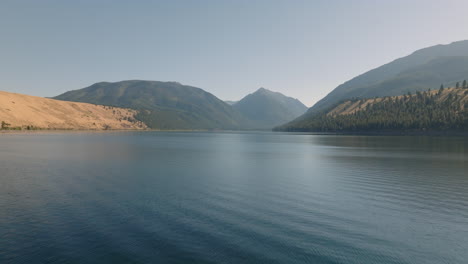 Low-Aerial-Footage-Over-Scenic-Lake-Surrounded-By-Mountains