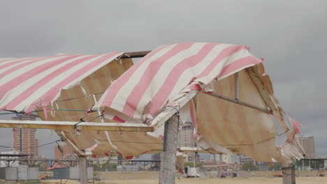 Ein-Zerbrochenes-Zelt-Flattert-Im-Wind-Am-Strand,-Bewölkt-In-Der-Bucht