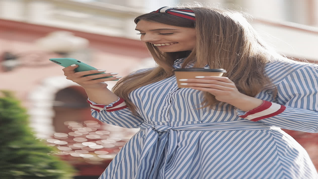 Giovane donna felice che sorride mentre usa lo smartphone e tiene in mano un caffè.