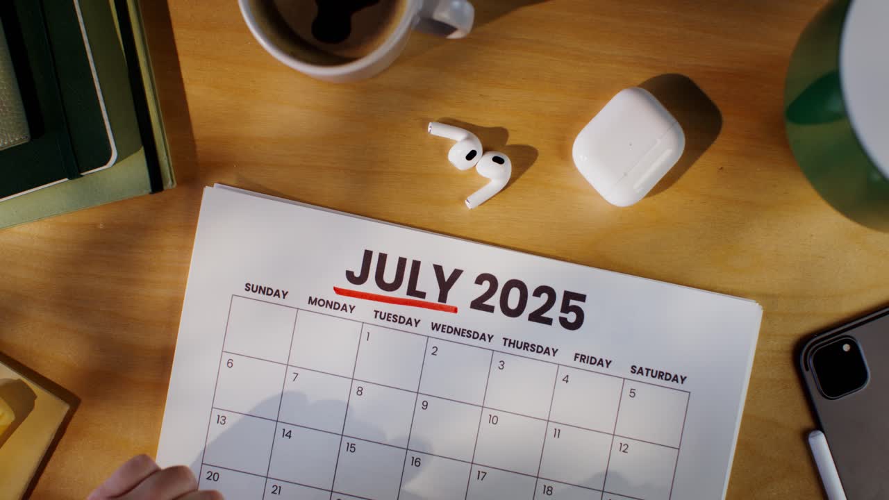Person Planning for July 2025 on a Desk Calendar