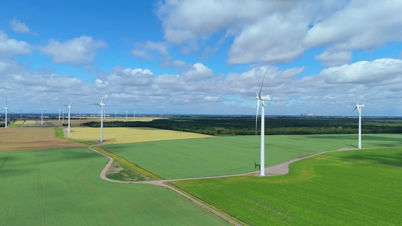 Wind turbine rotating in countryside generating power aerial drone view