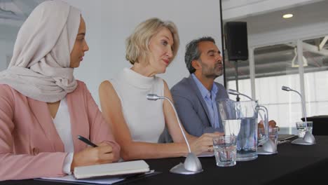 a panel of business delegates talking at a conference