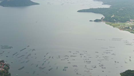 Vista-Aérea-Del-Lago-Taal-Que-Rodea-La-Isla-Del-Volcán-Taal-Y-La-Montaña-Silueta-Al-Fondo