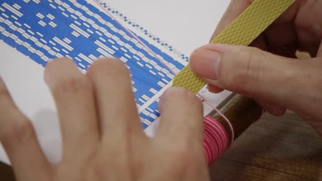 Fingers-of-seamstress-aligning-patterns-off-paper-with