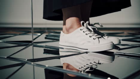 white sneakers and black skirt on a reflective surface