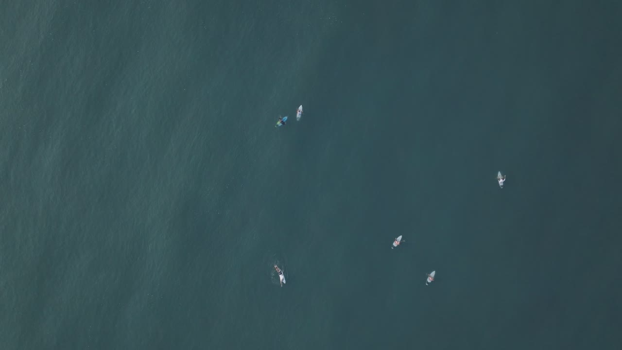 vista aérea en cámara lenta de los surfistas al amanecer la bocana el tunco el salvador