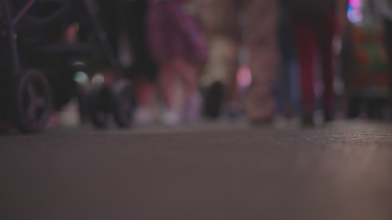 multitud de personas caminando por una calle de la ciudad por la noche