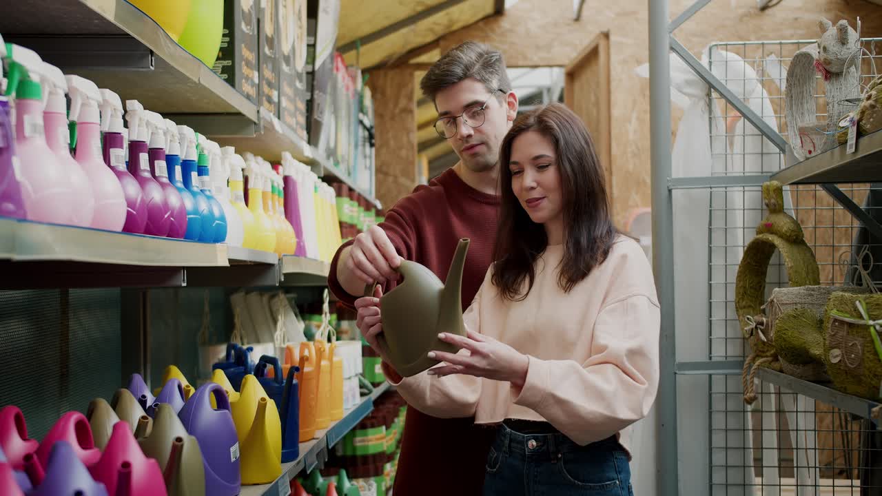compras de herramientas de jardín: pareja joven seleccionando una boquilla de manguera
