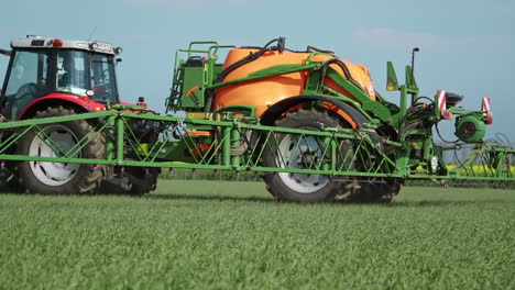 tractor agrícola conduciendo por la cámara y aplicando pesticidas con rociador