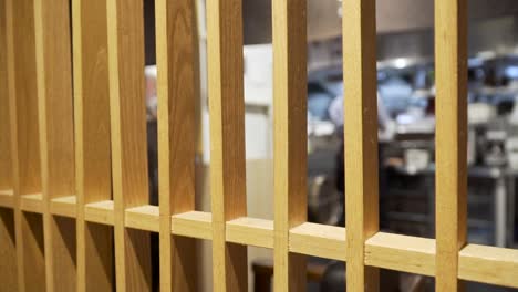 view inside restaurant kitchen through wooden bars