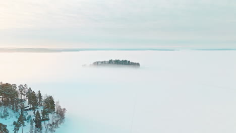 a small island or isle in middle of a frozen lake or sea ice engulfed in fog or mist