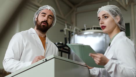 hombre y mujer haciendo control en la cervecería