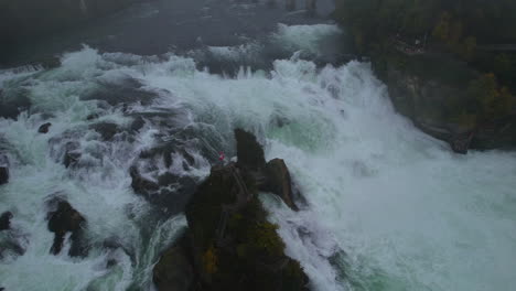 captivating aerial footage showcasing rhine falls' powerful cascades and laufen castle shrouded in fog. serene and breathtaking natural scenery