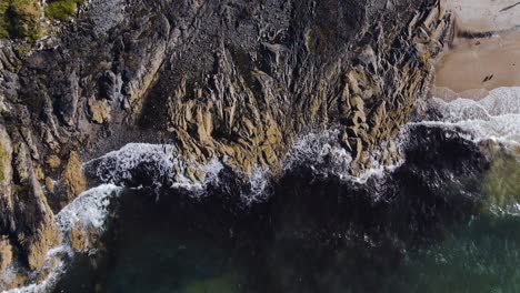 4k birds eye view of coastal waves crashing on rocks, slow motion