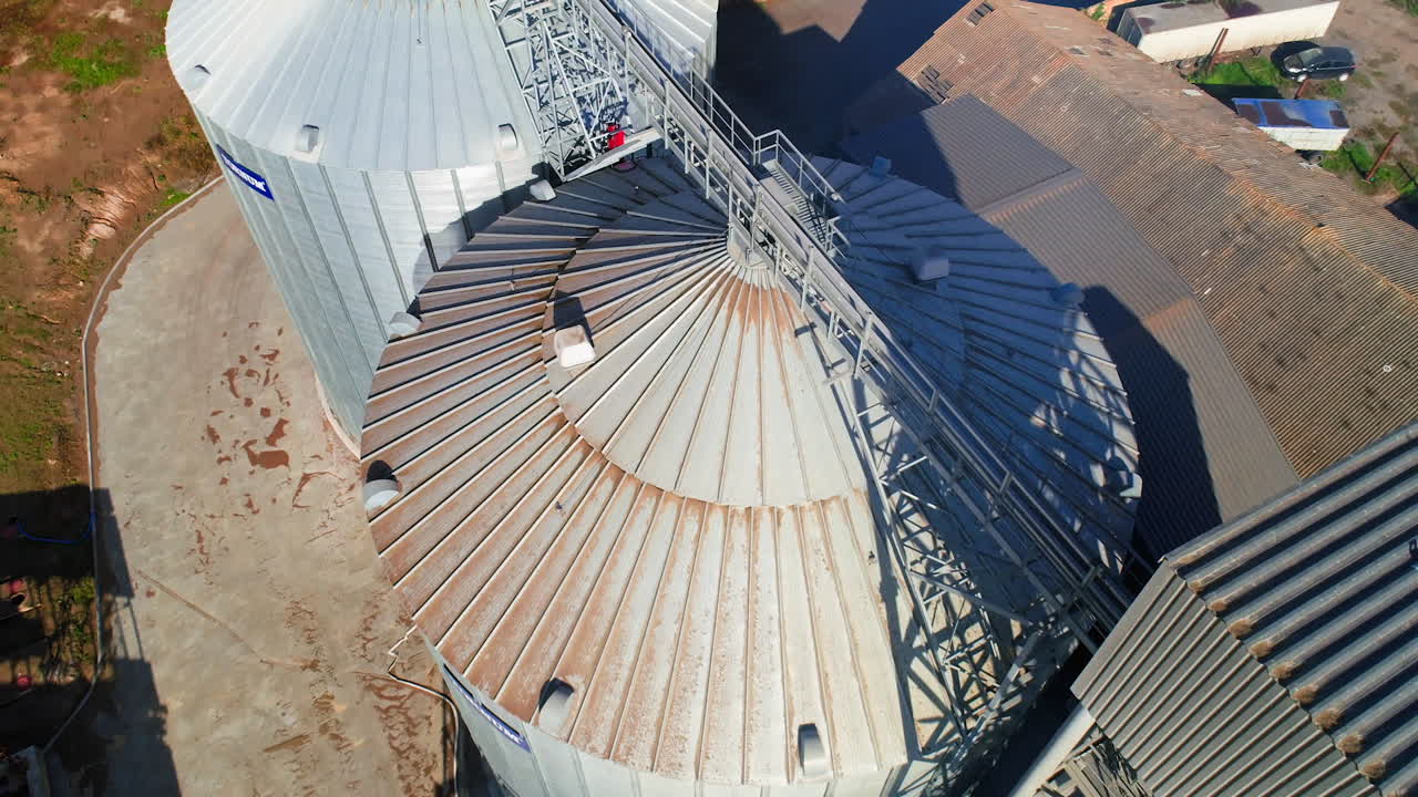 Aerial view of metal grain elevator in agricultural zone. Grain warehouse