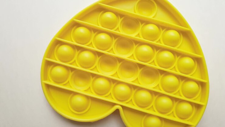 New baby toy. Pop it finger play. Funny color. Adult hand squeeze round silicone. Change form. Yellow heart shape