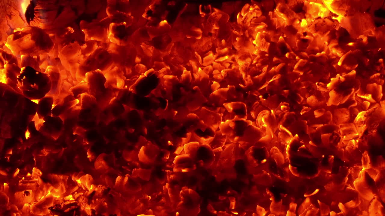 Campfire coals glowing orange embers with flames