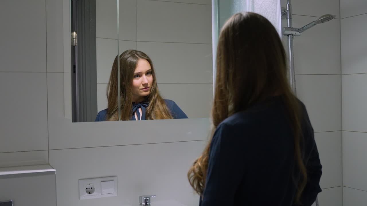 Giovane donna in carriera che prova un discorso allo specchio del bagno