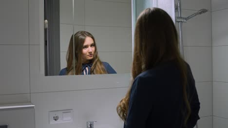 Young-corporate-woman-practicing-speech-in-bathroom-mirror