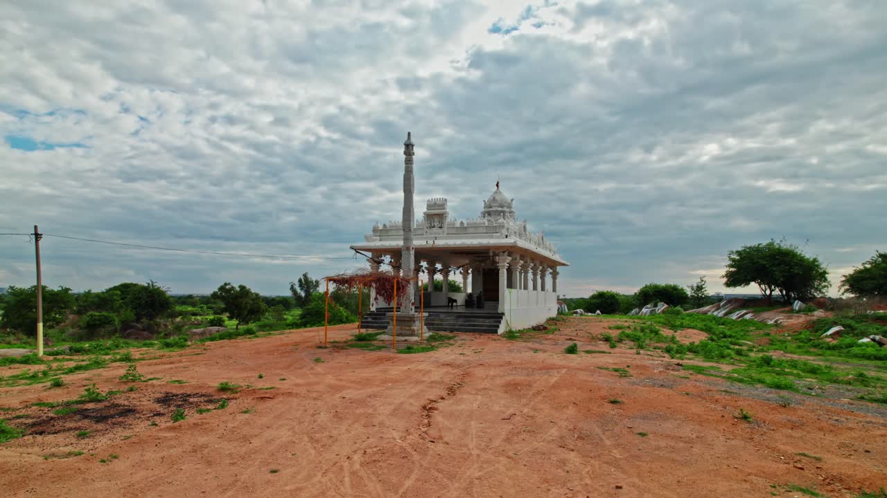 rainy clouds with newly constructed Hindu temple and dwajasthambam day time, low angle, semi circle, drone shot, 4k.