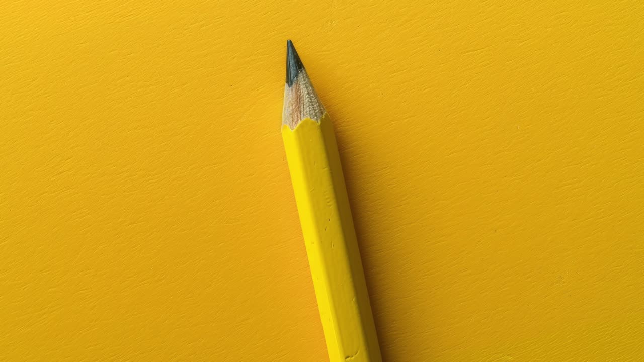 lápiz amarillo afilado sobre un fondo amarillo vibrante