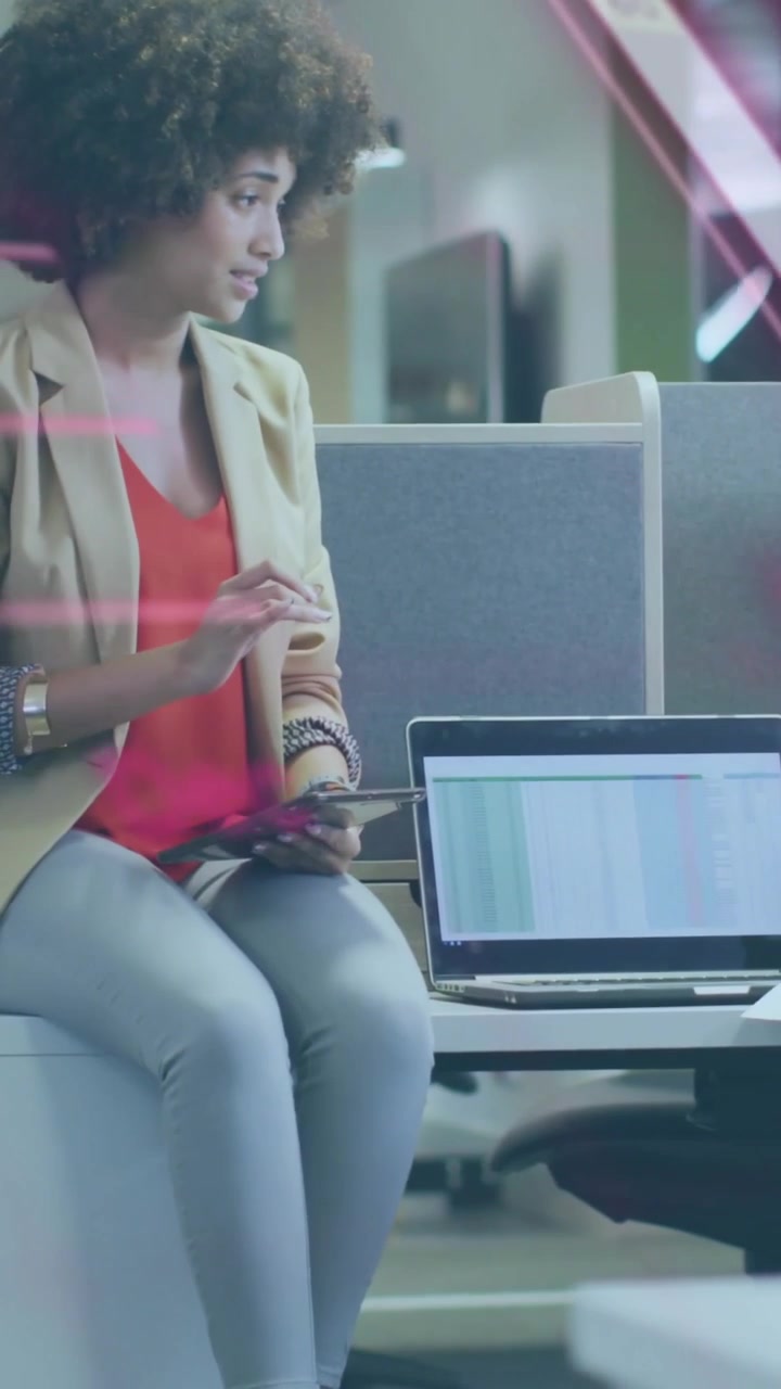 Vertical video: Woman sitting tapping tablet on peer cue showing magenta sheet overlay in business