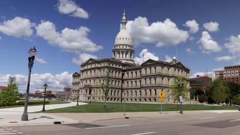 Michigan-state-capitol-building-in-Lansing,-Michigan-with-ground-level-time-lapse-video-showing-slow-moving-clouds-with-zoom-in