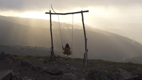 mujer columpiándose en un columpio en lousa baloico al atardecer, portugal