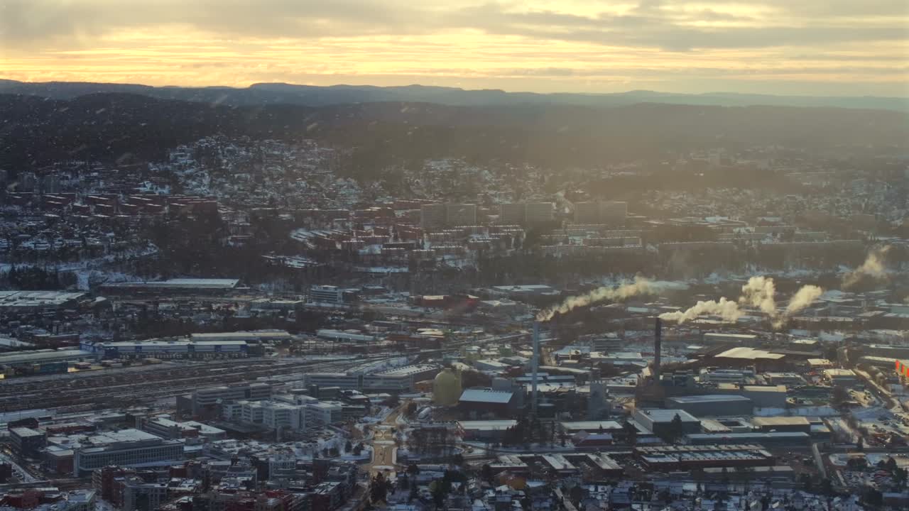 Oslo Norway Norge aerial view drone winter sunrise sunset industrial industry power plant haystack smoke cooling towers city landscape buildings golden yellow clear skies highway snowing circle right