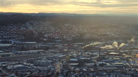 oslo norway norge aerial view drone winter sunrise sunset industrial industry power plant haystack smoke cooling towers city landscape buildings golden yellow clear skies highway snowing circle right