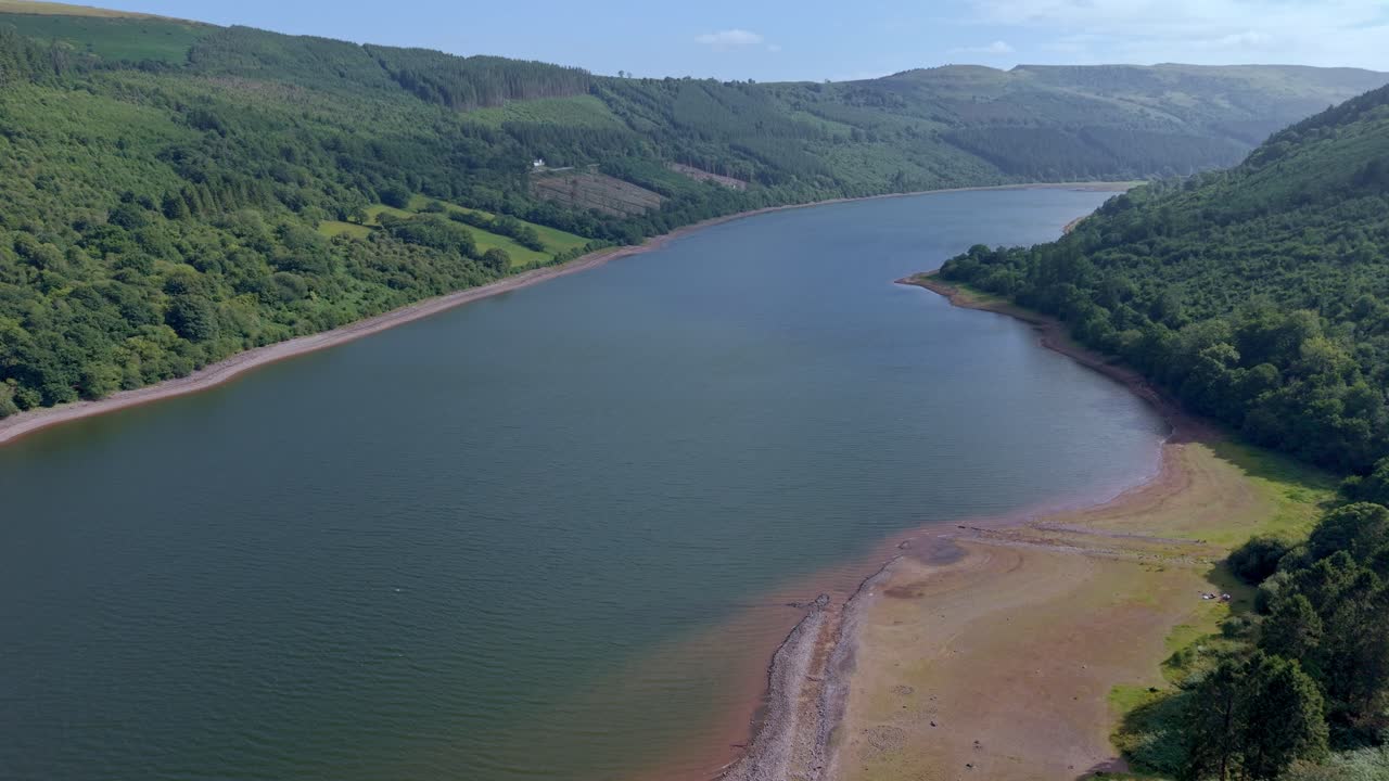 Scenic landscape of a large reservoir surrounded by lush green forests and hills