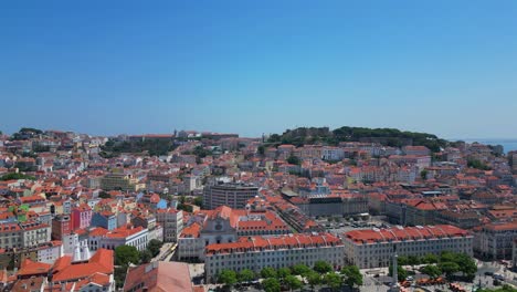 flying towards rossio square with lisbon cityscape and são jorge castle at background. lisbon, portugal