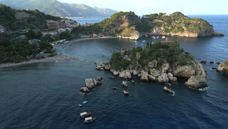 4k aerial of isola bella at sunset, in taormina, sicily in july 2025