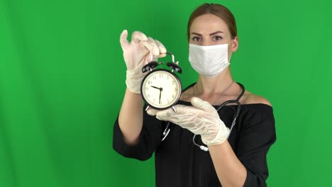 concept de estilo de vida saludable de la mujer médica - sosteniendo el despertador negro en la pantalla verde