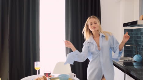 Blonde-woman-with-glass-of-red-wine-dancing-at-home.