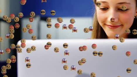 animation of emoticons over happy caucasian boy and girl using laptops