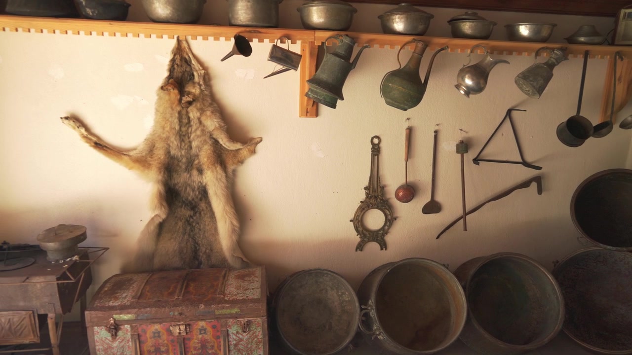 Collezione di stoviglie antiche in rame e pelliccia di animale in una stanza rustica