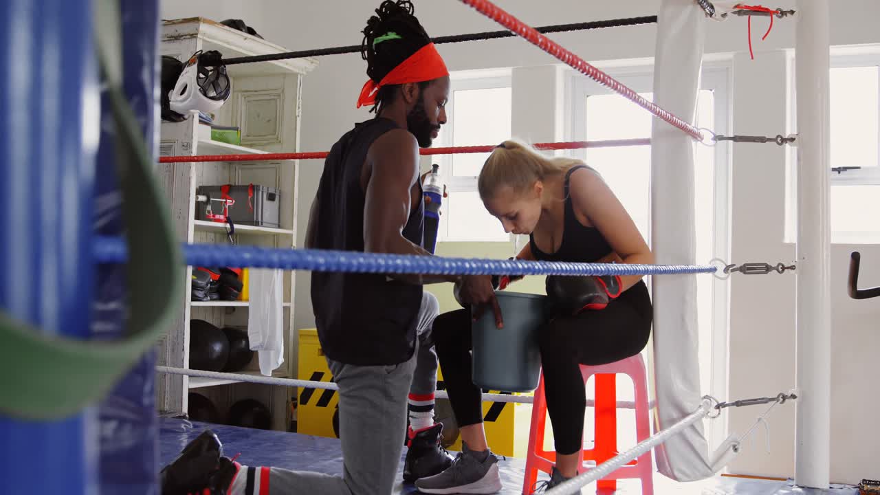 Female boxer relaxing in boxing ring 4k