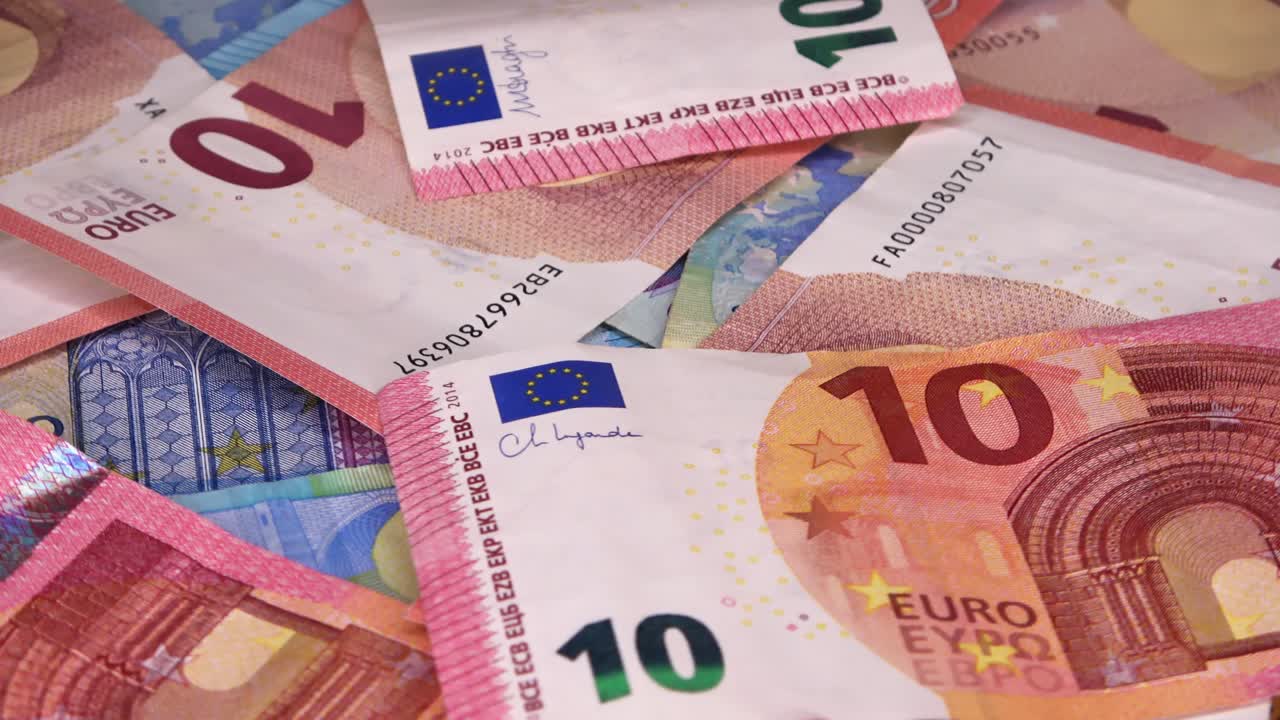 un primer plano en bucle de numerosos billetes de euro colocados uno encima del otro en una placa giratoria.