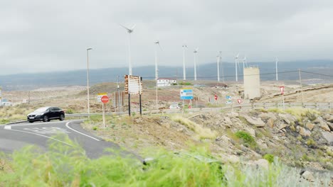 carretera de la isla de tenerife con tráfico y granja de turbinas eólicas en un día nublado