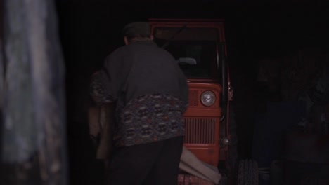 고령 농부가 차고에서 옷의 트랙터를 발견