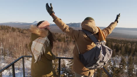 couple enjoying a winter mountain view from an observation tower