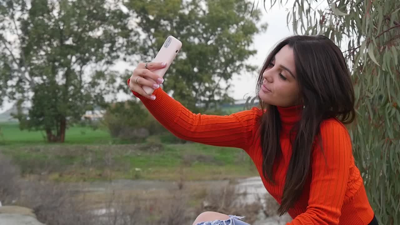 Young Woman Takes a Selfie Outdoors