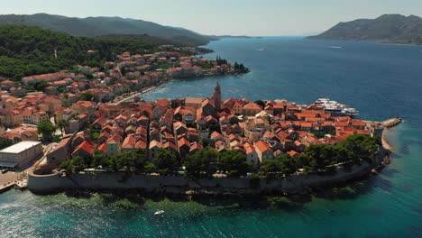 aerial view of a historic coastal town with red-tiled roofs and blue sea