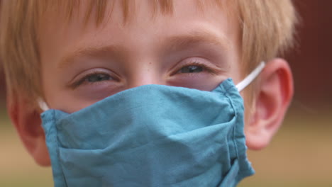 close up portrait of a cute little boy wearing a mask to help prevent the spread of coronavirus