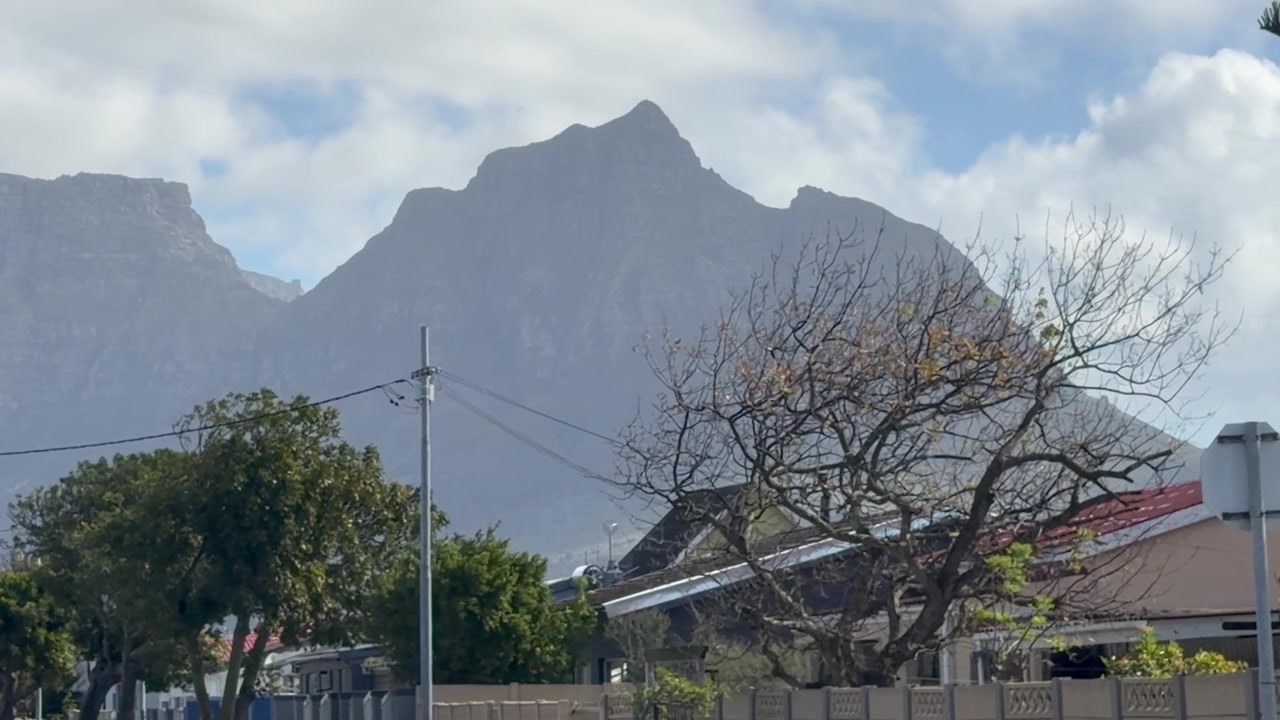 Puncak Iblis (Devil’s Peak) dan Gunung Meja (Table Mountain) seperti yang terlihat dari Pinggiran Kota Athlone di Cape Town, Afrika Selatan